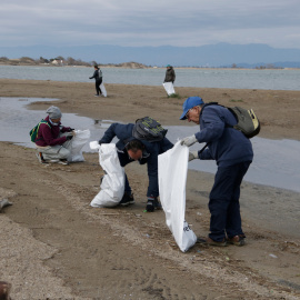 Diversos voluntaris de la jornada de neteja simultània al Parc Natural del delta de l'Ebre recullen deixalles al Garxal, a Deltebre.
