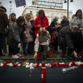 Varias personas participan en una ofrenda floral durante una manifestación de Marea de Residencias, a 23 de noviembre de 2024, en Madrid (España).