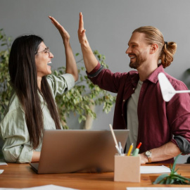 Dos personas chocando manos en el trabajo