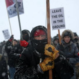 Un nativo americano y más ecologistas protestan contra el oleoducto de Energy Transfer en 2016, movilizaciones por las que Greenpeace ha recibido una condena millonaria.