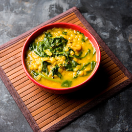 Imagen de un plato de lentejas con espinacas.