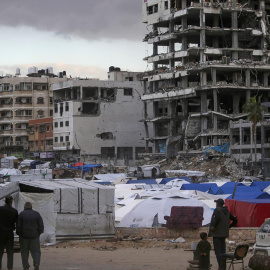 Grupos de palestinos desplazados del norte de Gaza se establecen cerca de edificios destruidos en la ciudad, el 20 de marzo de 2025,