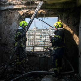 Varios rescatistas trabajan en el lugar en el que impactó un dron ruso, a 23 de marzo de 2025, en Kiev.