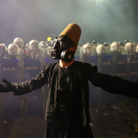 Un manifestante con una máscara de gas hace un gesto junto a la policía durante una protesta el día en que el alcalde de Estambul, Ekrem Imamoglu, fue encarcelado como parte de una investigación por corrupción, en Estambul, Turquía.