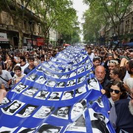 La gente lleva una pancarta con imágenes de personas desaparecidas, víctimas de la última dictadura de Argentina, durante una manifestación para conmemorar el 49 aniversario del golpe militar de 1976, en la Plaza de Mayo de Buenos Aires.
