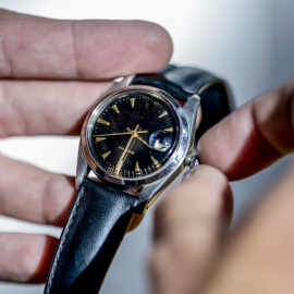 Un home canvia l'hora del rellotge