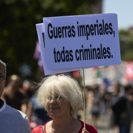 Una mujer sostiene una pancarta contra la guerra, a 26 de junio de 2022, en Madrid.