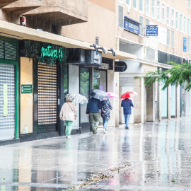 Imagen de varias personas protegiéndose de la lluvia en Las Palmas de Gran Canaria.
