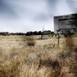 Imagen de archivo de una pintada sobre una valla publicitaria en la que se lee "Centro por la memoria, pisos no", en el terreno en el que se encontraba la antigua carcel de Carabanchel.