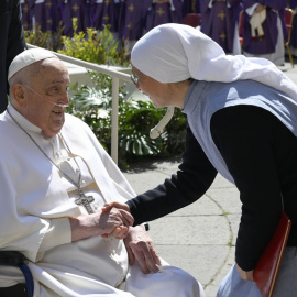 El papa Francisco saluda a una monja antes de presentarse en persona ante los fieles en la Plaza de San Pedro.
