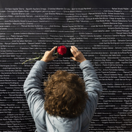 Una mujer hace una foto del nombre de su familiar durante el acto de cierre de la fosa de Pico Reja. Archivo