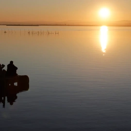 Un grup de persones observa la posta de sol a l'Albufera de València