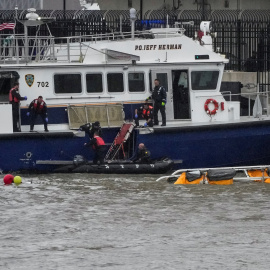Los equipos de emergencias tratan de recuperar el helicóptero accidentado en Nueva York.