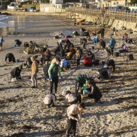 Imagen de archivo de arios voluntarios recogen pellets en la playa de Panxón, en Galicia.