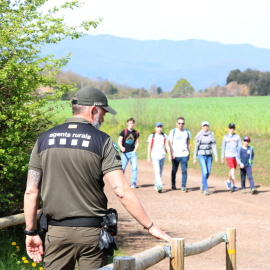 Un agent rural a l'entrada del volcà Cruscat amb uns visitants que arriben