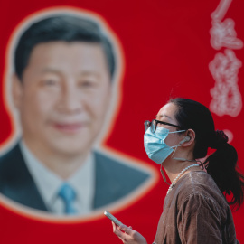 Una mujer camina frente a un retrato del presidente chino Xi Jinping en Shanghái, China, el 1 de abril de 2025.