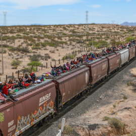 Personas migrantes de diferentes nacionalidades que buscan asilo en Estados Unidos viajan en vagones de carga del tren mexicano conocido como "La Bestia".