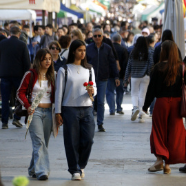 Dues noies amb roses a la mà a la rambla de Ferran de Lleida per Sant Jordi.