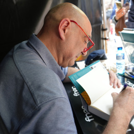 Xavier Bosch signant exemplars del seu darrer llibre en una parada de Sant Jordi.