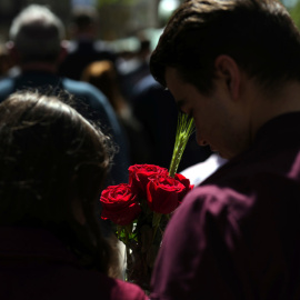 Una pareja con varias rosas camina por el centro de Barcelona durante la Diada de Sant Jordi.