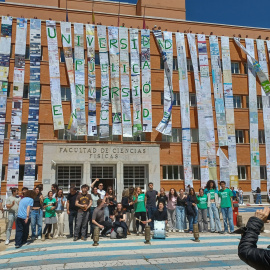Profesores de la Complutense cubren la facha de la Facultad de Físicas con un gran mural, confeccionado con más de 400 pósteres de investigación presentados en congresos, bajo el lema "Universidad pública, inversión en calidad".