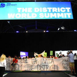 Manifestants amb una pancarta en contra de la celebració del congrés The District, a l'interior del recinte