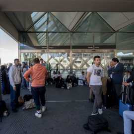 Varios pasajeros aguardan en las inmediaciones de la estación de Atocha tras el apagón eléctrico masivo, a 28 de abril de 2025.