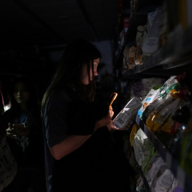 Una joven en una tienda de Barcelona durante el gran apagón que sufrió España.