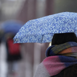 Una persona se protege de la lluvia con un paraguas.