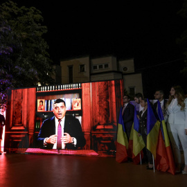 El líder de AUR, George Simion, da un discurso en televisión, visto desde las pantallas en la sede de la formación, a 4 de mayo de 2025.