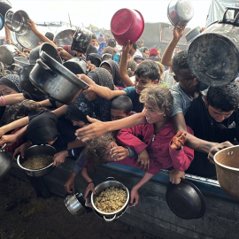 Los palestinos luchan por recibir comida caliente distribuida por organizaciones benéficas en medio de los continuos ataques israelíes y el bloqueo total de Gaza.