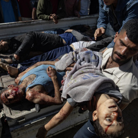 Un hombre saca de una camioneta el cadáver de un niño asesinado por Israel en un bombardeo sobre un restaurante y un mercado que el pasado miércoles costó la vida a 25 personas en Gaza.