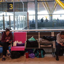 Foto de archivo de varias personas sentadas en la terminal T4 del aeropuerto Adolfo Suárez-Madrid Barajas.