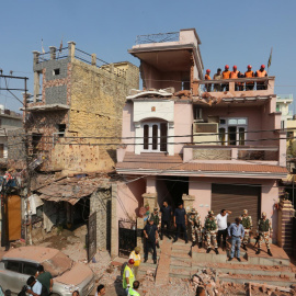 Voluntarios de la Defensa Civil de la India y personal de seguridad se encuentran frente a una casa dañada tras un bombardeo transfronterizo desde Pakistán, en la ciudad de Jammu, India, el 10 de mayo de 2025.