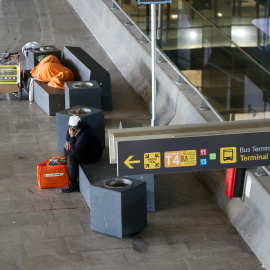 Imagen de dos personas sin hogar en la Terminal 4 de Barajas.