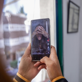 Imagen de archivo de una persona viendo el vídeo de una joven en la red social TikTok, a 22 de septiembre de 2020.
