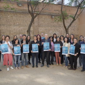 Representants d'entitats socials, de lleure i educatives amb el cartell de la campanya 'A l'estiu ens hi juguem molt'