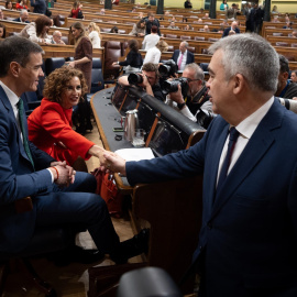 El presidente del Gobierno, Pedro Sánchez y la vicepresidenta primera y ministra de Hacienda, María Jesús Montero, que saluda al secretario de Organización del PSOE, Santos Cerdán, durante una sesión plenaria en el Congreso de los Diputados
