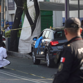 Peritos forenses trabajan en la zona donde fue asesinada la secretaria particular de la Jefa de Gobierno Clara Brugada, en una avenida principal de la Ciudad de México.
