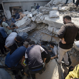 Imagen de civiles palestinos buscando desaparecidos bajo los escombros de la casa de la familia Dardona, bombardeada en la noche de este jueves.