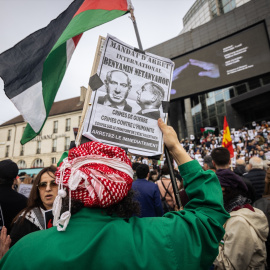 Un manifestante sostiene un cartel con la cara de Benjamin Netanyahu que dice "Orden de Arresto", durante una manifestación en la Plaza de la Bastilla, en París.