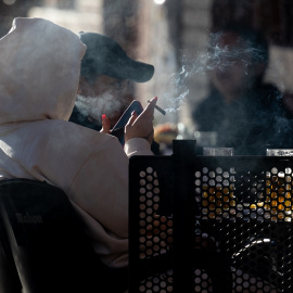 Una persona fumando en una terraza, a 27 de diciembre de 2023, en Madrid