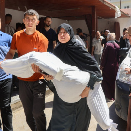 Una mujer carga con el cadáver de un familiar en Jabalia tras un ataque israelí.
