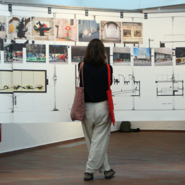 Una dona observa diverses fotografies i plànols a l'exposició a la Fundació Joan Miró