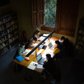 Varias personas en la sala de estudios de la Facultad de Filología y Comunicación Universidad de Barcelona.