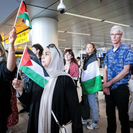 La gente ondea banderas palestinas mientras los participantes de la "Marcha Global a Gaza" parten del aeropuerto de Schiphol hacia Egipto en Schiphol, Países Bajos, el 11 de junio de 2025.