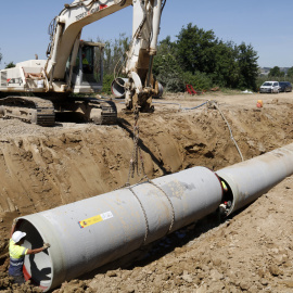 Operaris instal·lant un tub de reg en el marc dels treballs de modernització del canal de Pinyana, a Alguaire