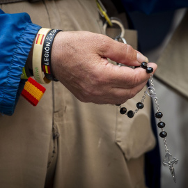 Una persona sostiene un rosario durante una concentración para rezar colectivamente.