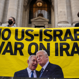 Protesters hold a banner with a message and images of U.S. President Donald Trump and Israeli Prime Minister Benjamin Netanyahu during a 'No War on Iran' rally in New York City, U.S., June 18, 2025. REUTERS/David 'Dee' Delgado