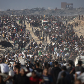 Palestinos desplazados transportan paquetes de ayuda humanitaria a lo largo de la calle Rashid, al oeste de Jabalia, el 22 de junio de 2025.
